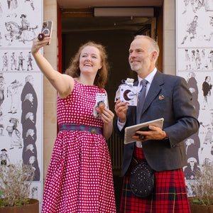 Alison Grieve and James Macsween take a selfie with the new Haggis phone holder on the iPhone 13 Pro in front of the Museum of Edinburgh